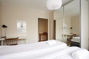 a bedroom with a large white bed and a mirror at Jokiranta asunto, Free-park in Turku