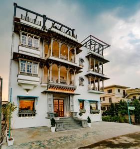 a large white building with a lot of windows at Khamma Ghani A Boutique Hotel in Udaipur