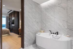a bathroom with a bath tub and a bedroom at JW Marriott Hotel Istanbul Marmara Sea in Istanbul