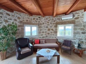 uma sala de estar com um sofá e duas cadeiras em Rokka Pyrgos Amazing View - Maistros em Falelianá