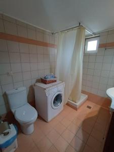 uma casa de banho com um WC e uma máquina de lavar roupa em Rokka Pyrgos Amazing View - Maistros em Falelianá