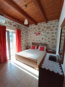 um quarto com uma cama grande e almofadas vermelhas em Rokka Pyrgos Amazing View - Maistros em Falelianá