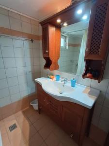 uma casa de banho com um lavatório, um espelho e um WC. em Rokka Pyrgos Amazing View - Maistros em Falelianá