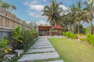 a garden with a pathway leading to a house at Kubu Selat Villa and Glamping in Gianyar