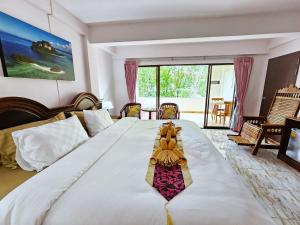 duże białe łóżko w pokoju z dużym oknem w obiekcie Lanta MP Place w mieście Ko Lanta