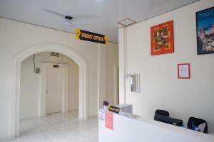 une salle d'attente avec un panneau indiquant les soins urgents dans l'établissement RedDoorz near Terminal Bus Purwokerto, à Banyumas