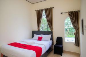 una camera con un letto con una coperta rossa di RedDoorz near Terminal Bus Purwokerto a Banyumas