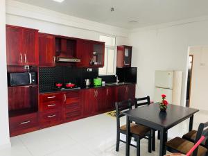 a kitchen with wooden cabinets and a table with chairs at Rideway wellawatte in Colombo