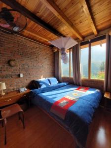 um quarto com uma cama grande e uma parede de tijolos em Sapa's Soul em Sa Pa