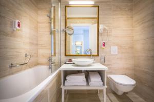 a bathroom with a sink and a tub and a toilet at Hotel Bellevue - Liburnia in Opatija