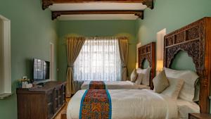 a bedroom with two beds and a window at Khamma Ghani A Boutique Hotel in Udaipur