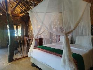 a bedroom with a bed with a canopy at Mario Hotel and Cafe in Weetebula