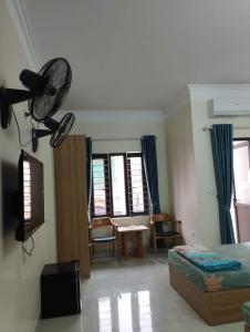 a room with a bed and a fan in it at Anh Tuấn Hotel in Ha Long