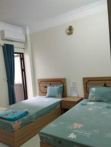 two beds sitting next to each other in a bedroom at Anh Tuấn Hotel in Ha Long