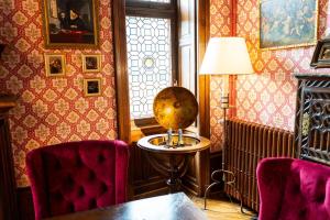 une chambre avec une table, deux chaises et une lampe dans l'établissement Le Manoir Saint Thomas, à Amboise