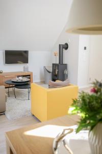 a living room with a stove on a yellow cabinet at Ostsee - Appartement "Pier 76" im Strand Resort in Heiligenhafen