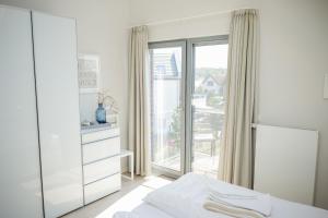 ハイリゲンハーフェンにあるOstsee - Appartement "Pier 76" im Strand Resortのベッドルーム1室(ベッド1台、大きな窓付)