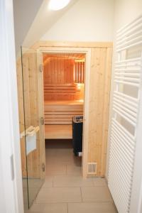 an empty sauna with a glass door in a room at Ostsee - Appartement "Pier 76" im Strand Resort in Heiligenhafen