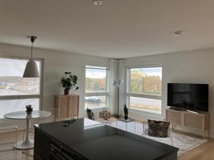 ein Wohnzimmer mit einem Flachbild-TV und einem Tisch in der Unterkunft Seaside Lux in Turku