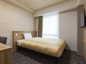 um quarto de hotel com uma cama e uma janela em Kyoto Plaza Hotel Kintetsu Jujo em Quioto