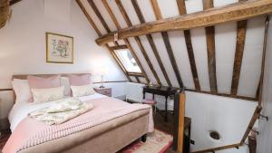 sypialnia z różowym łóżkiem na poddaszu w obiekcie Joe's Cottage w mieście Bridgnorth