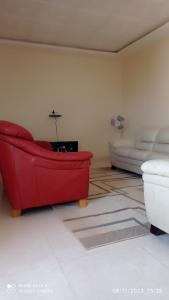 sala de estar con sofá rojo y cama en chez Mamanta, en Saint-Louis