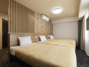 two beds in a hotel room with at Kyoto Plaza Hotel Kintetsu Jujo in Kyoto