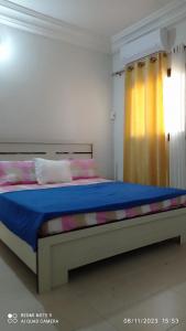 a bedroom with a large bed with a blue blanket at chez Mamanta in Saint-Louis