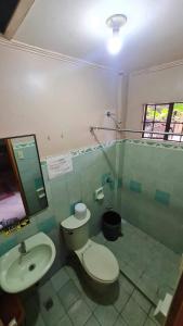 a bathroom with a toilet and a sink at RedDoorz @ D'Little Egg Hostel Pangasinan in Urdaneta