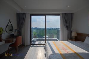 a bedroom with a bed and a large glass window at Maihomes Hotel Vĩnh Yên Vĩnh Phúc in Yen