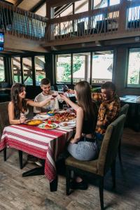 Un gruppo di persone seduti intorno a un tavolo che mangiano cibo di BRB Park Hotel a Vizhenka