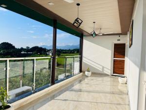 an empty balcony with a view of the mountains at GREEN DANDI HOMESTAY in Rishīkesh