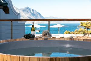 uma banheira de hidromassagem com uma garrafa de vinho e copos de vinho em Harbour House Hotel em Hermanus