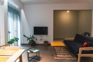 een woonkamer met een bank en een flatscreen-tv bij Ba & Bu Apartment 1 in Kateríni