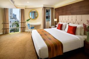 una camera d'albergo con un grande letto e un tavolo di Court Wing Hotel Sukhumvit Bangkok a Bangkok