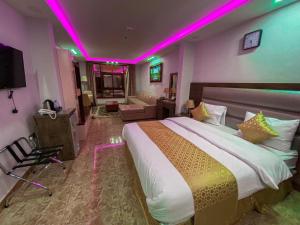 a bedroom with a large bed with purple lights at فندق ماس الوجه in Al Wajh