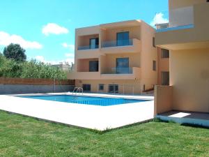 a villa with a swimming pool in front of a house at Gerona Mare Apartments in Gerani