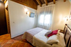 a small bedroom with a bed and a window at Apartamentos El Pedrayu in Onís