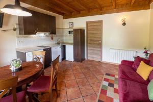 eine Küche und ein Wohnzimmer mit einem Tisch und Stühlen in der Unterkunft Apartamentos El Pedrayu in Onís