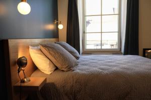um quarto com uma cama com almofadas e uma janela em Les 7 Frères em Monestier-de-Clermont