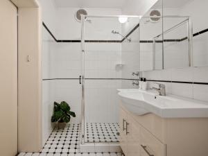 a white bathroom with a sink and a shower at The Metropole Guest House Katoomba in Katoomba
