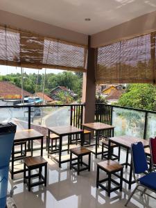 um restaurante com mesas e cadeiras e janelas grandes em L'JAVAS VILLAS em Kalibendo
