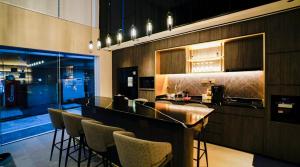 a kitchen with a bar with stools in it at ST Signature Bugis Middle in Singapore