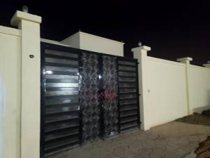 a black gate on a white fence at night at Villa Ria RAK in Ras al Khaimah