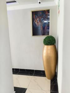 a large vase with a plant in the corner of a room at Essential Lodge23 in Cape Town