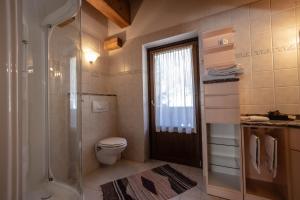 een badkamer met een douche, een toilet en een raam bij Hotel Bouton D'Or - Cogne in Cogne