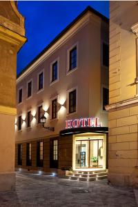 un hotel con un cartel en el lateral de un edificio en Hotel Capitulum, en Győr