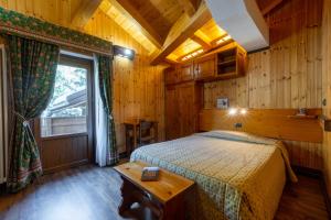 een slaapkamer met een bed in een houten kamer bij Hotel Bouton D'Or - Cogne in Cogne