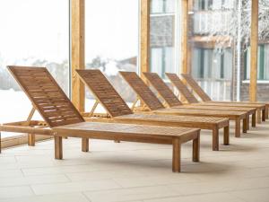a row of wooden chairs sitting on a balcony at Spacious Chalet near Ski Area in Sankt Georgen ob Murau in Sankt Lorenzen ob Murau