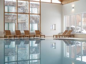 a room with a pool with chairs and windows at Spacious Chalet near Ski Area in Sankt Georgen ob Murau in Sankt Lorenzen ob Murau